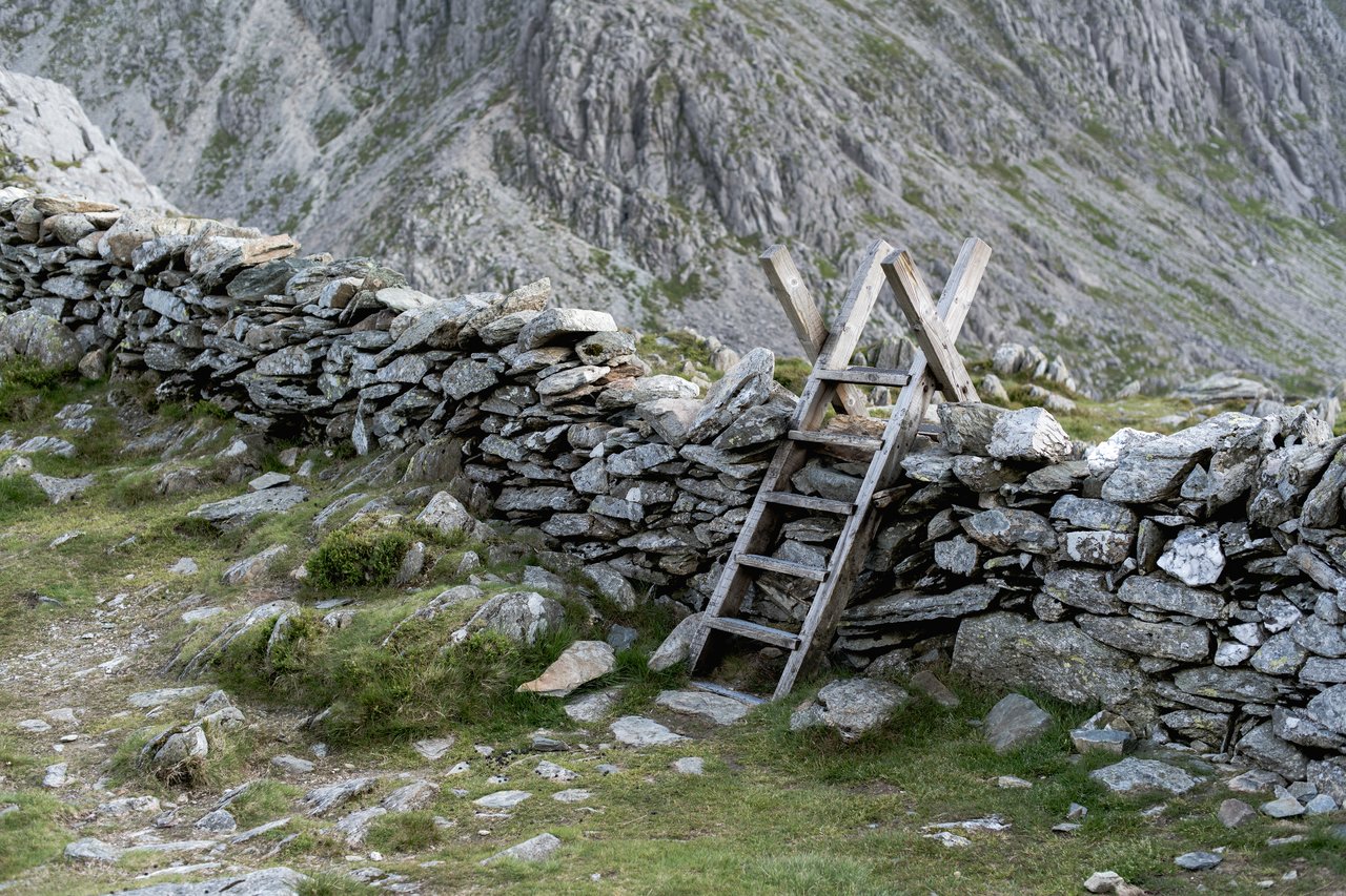 Hiking Ogwen Valley in Snowdonia A stone wall with a step ladder