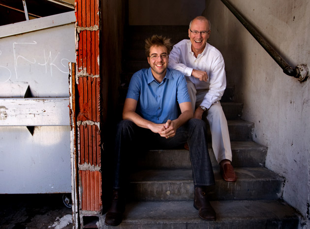 Wired interview Two men sitting on outdoor concrete stairs, both smiling at the camera.
